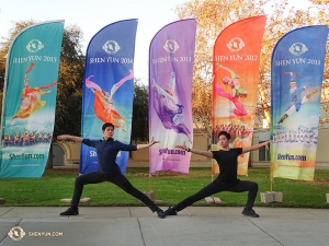 エスコンディードに掲げられた色鮮やかな５年分の神韻バナーの前でポーズをとるダンサーのダニー・リーとヘンリー・ホン（右）。現在、神韻ニューヨーク芸術団がロンドンで行っている14回公演は全て完売（撮影：ダンサー、トニー・ジャオ）